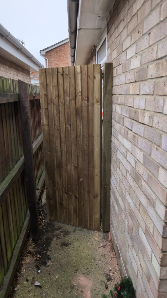 Custom wooden side gate built to size in a narrow alleyway